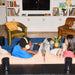 Two people sitting on a sofa with a dog and a black Beam Ultra soundbar in a modern living room
